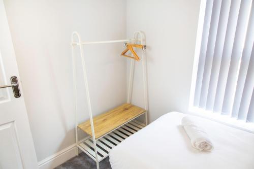 a room with a bed with a wooden shelf next to a window at 4 Bedrooms Spacious House With 2 Bathrooms Free Parking - sleeps up to 10 guests in Liverpool