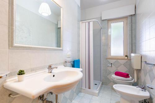 y baño con lavabo, aseo y espejo. en Appartamento Trieste Trilo 2 - MyHo Casa, en Alba Adriatica