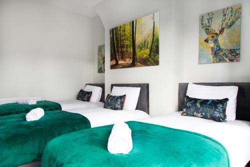 a room with three beds with green sheets at 4 Bedrooms Spacious House With 2 Bathrooms Free Parking - sleeps up to 10 guests in Liverpool