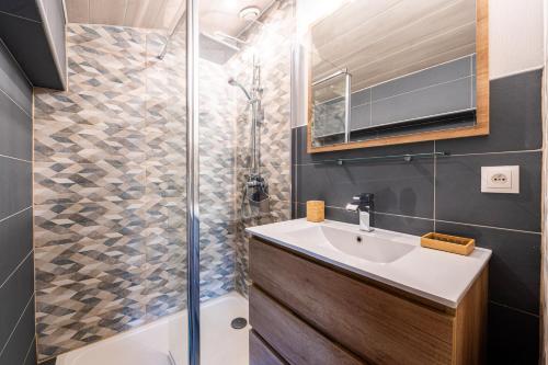 une salle de bain avec un lavabo et une douche dans l'établissement Appartement Les Genevriers, au Grand-Bornand