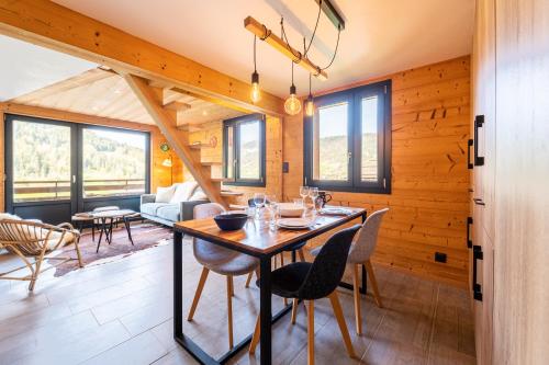 une salle à manger et un salon avec une table et des chaises dans l'établissement Appartement Les Genevriers, au Grand-Bornand