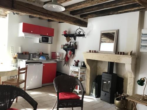 une cuisine avec une cheminée, une table et des chaises dans l'établissement L'Atelier de Pierre 1-Bed Cottage in Pousseaux, à Pousseaux