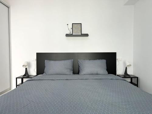 ein Bett mit einem schwarzen Kopfteil und zwei Lampen in der Unterkunft Walk into Dream of Acropolis 10 in Athen