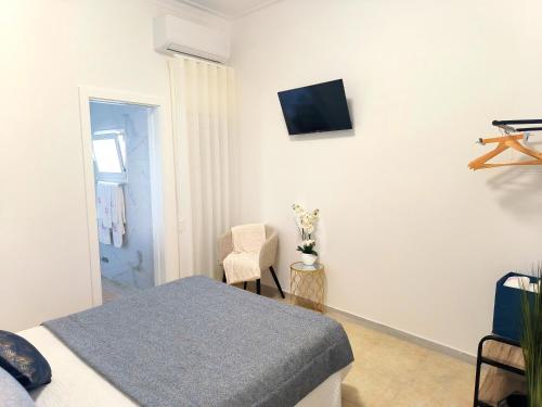 a bedroom with a bed and a tv on the wall at MAR ROSA, estacionamento gratuito in Nazaré