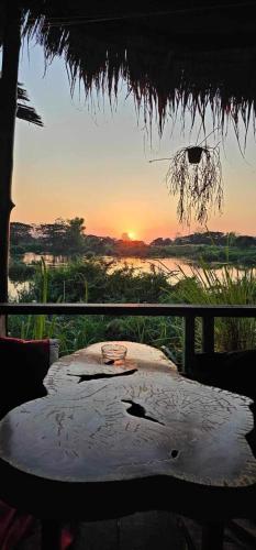 a table with a view of the sunset from a field at Kulap Kao Bungalow in Ban Donsôm Tai