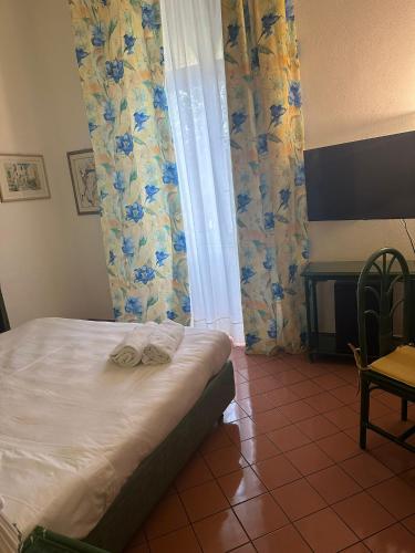 a bedroom with a bed and a desk in a room at Hotel Baia Delle Sirene in Taormina