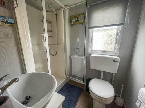 a bathroom with a toilet and a sink and a tub at Lovely 8 Berth Caravan At California Cliffs Holiday Park In Norfolk Ref 50053c in Great Yarmouth