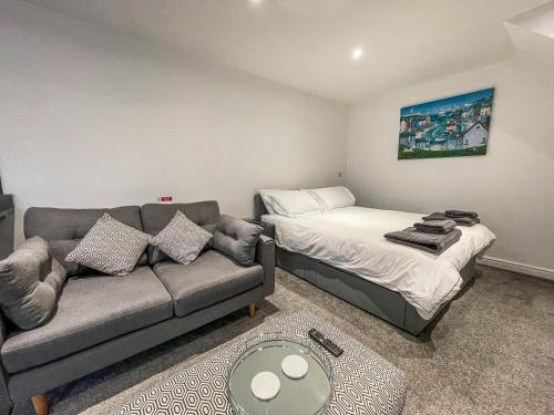a living room with a couch and a bed at Modern 2 Berth Seaside Studio Apartment On Ground Floor In Hemsby, Ref 99011ws in Great Yarmouth