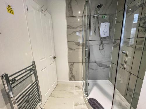a shower in a bathroom with a glass shower stall at Modern 2 Berth Seaside Studio Apartment On Ground Floor In Hemsby, Ref 99011ws in Great Yarmouth