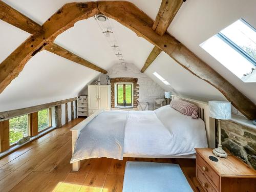 a bedroom with a large bed and wooden floors at Meadow Barn in Shelve