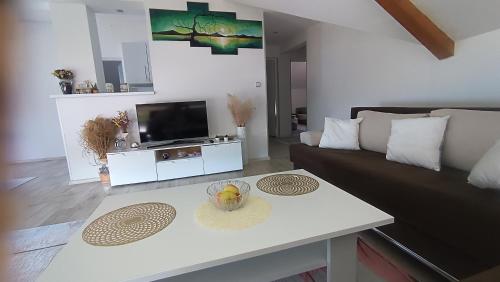a living room with a couch and a table at Lejla apartmani - Jablaničko jezero in Konjic