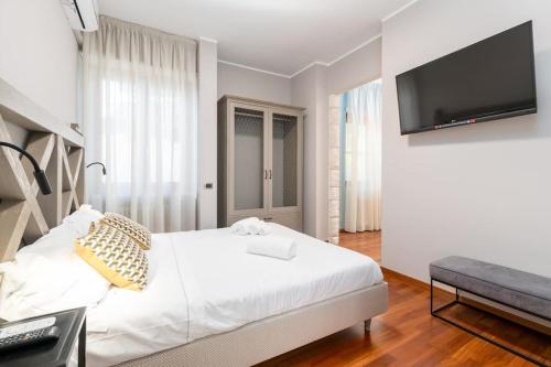 a bedroom with a white bed and a flat screen tv at Villa D'Aprile Exclusive Luxury Villa with pool, Jacuzzi, SPA in Castellana Grotte