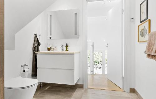 Baño blanco con aseo y lavamanos en Cozy Home In Asperup With Kitchen en Asperup