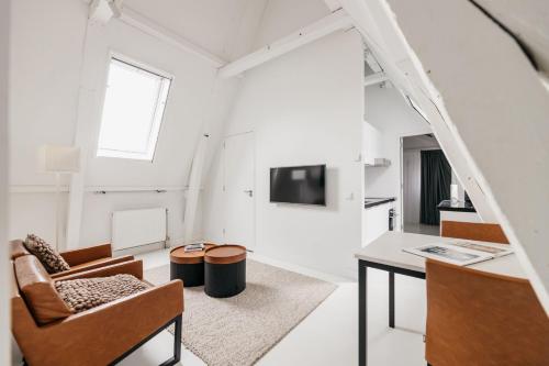 a white living room with a table and chairs at YAYS Amsterdam Salthouse Canal by Numa in Amsterdam