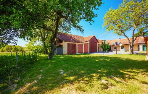 an old barn with a tree in the yard at Stunning Home In Ivanska in Ivanska