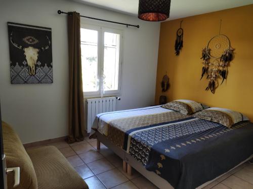 une chambre avec un lit et une fenêtre dans l'établissement Maison provençale, à Pernes-les-Fontaines