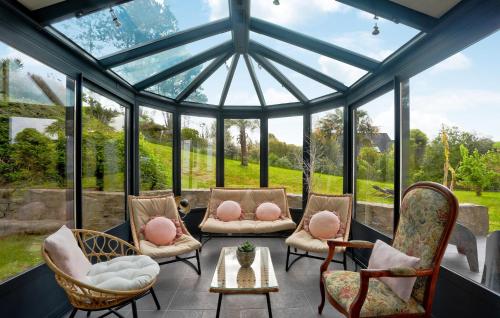 une véranda avec un toit en verre, des chaises et une table dans l'établissement Pet Friendly Home In Omonville-La-Rogue, à Omonville-la-Rogue