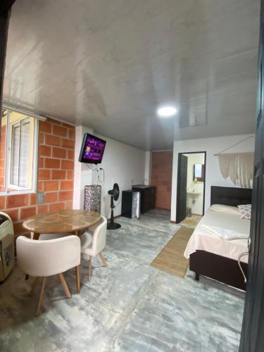 a room with a bed and a table and a bedroom at GREEN APARTMEN "el bosque" in Girón