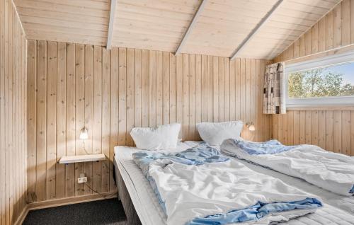 BolilmarkにあるBeautiful Home In Rm With Kitchenの木製の壁にベッド2台が備わるベッドルーム1室