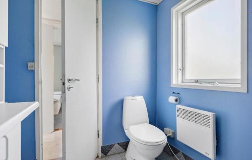 a blue bathroom with a toilet and a window at Beautiful Home In Middelfart With Wifi in Middelfart
