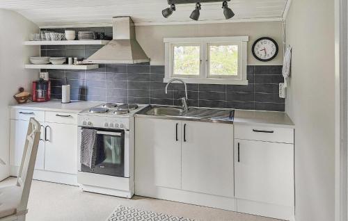 a kitchen with white cabinets and a sink and a window at Holiday Home Sjöbo Co Jå Hansson Svenljunga in Svenljunga