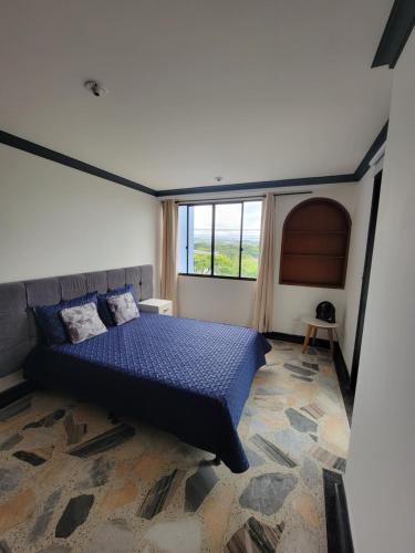 a bedroom with a bed and a large window at Bello y amplio apartamento cerca al aeropuerto in Pereira