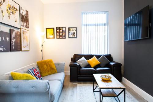 a living room with a couch and a table at 4 Bedrooms Spacious House With 2 Bathrooms Free Parking - sleeps up to 10 guests in Liverpool