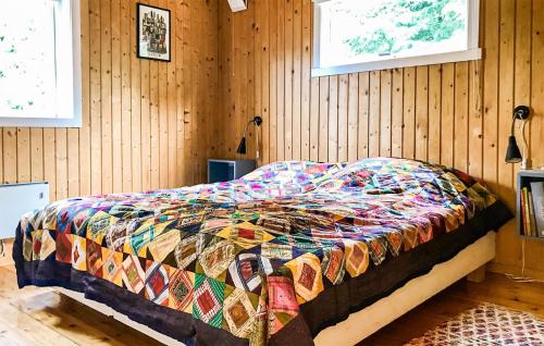 a bed with a colorful comforter in a room at Beautiful Home In Vejby With Wifi in Vejby