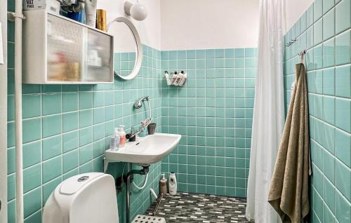 a blue tiled bathroom with a sink and a toilet at Beautiful Home In Vejby With Wifi in Vejby