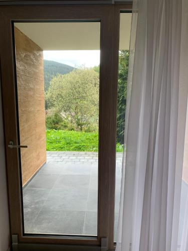 a glass door with a view of a patio at Apartmány Pec pod Sněžkou in Pec pod Sněžkou