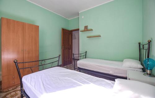 two beds in a room with green walls at Cozy Apartment In Perdifumo With Wifi in Perdifumo