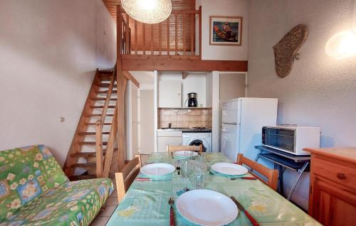 a small kitchen with a dining table and a staircase at 2 Bedroom Beautiful Home In Les Mathes in Les Mathes