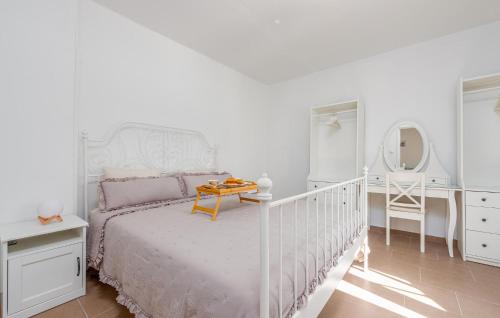 a white bedroom with a bed and a dressing table at Nice Home In Zemunik Donji With Kitchen in Smrdelje