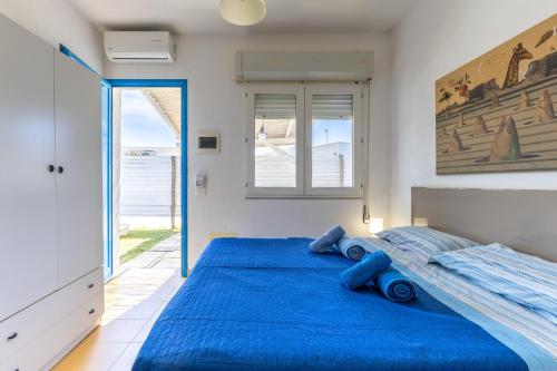 ein Schlafzimmer mit einem großen Bett mit blauer Bettwäsche in der Unterkunft Rocca dei Tramonti Apartments in Punta Braccetto