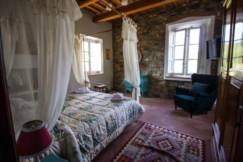 a bedroom with a bed and a chair and windows at Casa Locci in Capannori