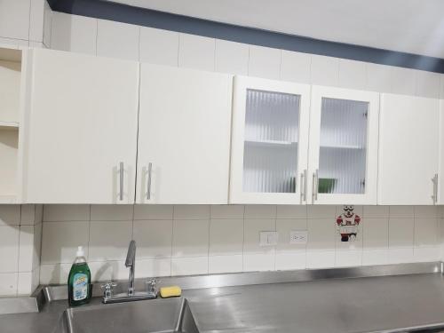 a kitchen with white cabinets and a sink at Bello y amplio apartamento cerca al aeropuerto in Pereira