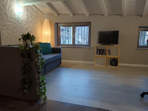 a living room with a blue couch and a tv at Casa Pedrarias in Lavena Ponte Tresa