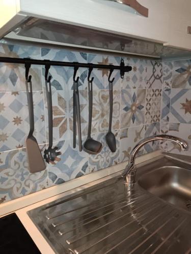 a group of utensils hanging on a kitchen wall at Casa Pedrarias in Lavena Ponte Tresa