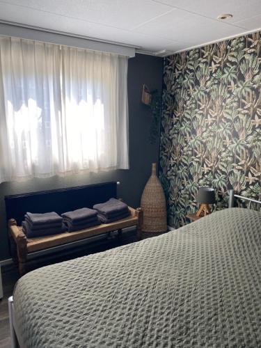 een slaapkamer met een bed en een raam bij Chalet Maiva - De Krabbenkreek in Sint Annaland