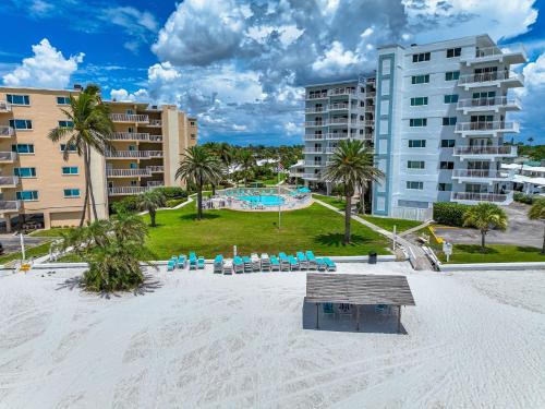 a beach with a pool and some palm trees and buildings at Jamaica Royale Beachfront Tower By Beachside Management in Siesta Key