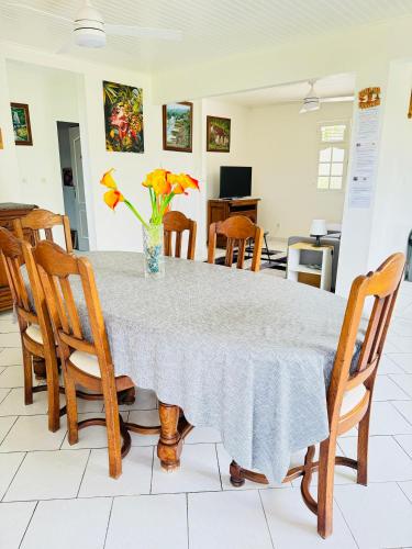 a dining room table with a vase of flowers on it at VILLA C'MARGOT in Marigot