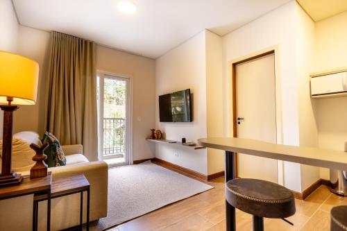 a living room with a table and a couch at Zur Suítes in Campos do Jordão