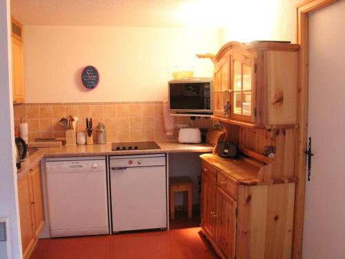 Il comprend une cuisine équipée d'une cuisinière et d'un réfrigérateur blanc. dans l'établissement Charmant 3 pièces à Châtel avec balcon, proche pistes et navettes, pour 6 personnes - FR-1-676-62, à Châtel