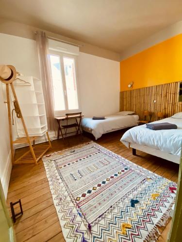 Cette chambre dispose de 2 lits et d'un tapis. dans l'établissement Les 3 Graces, Cayeux-sur-mer, agréable maison, à Cayeux-sur-Mer