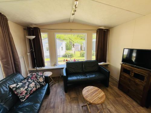 a living room with a couch and a flat screen tv at Vakantiepark Kijkduin - 711 in The Hague