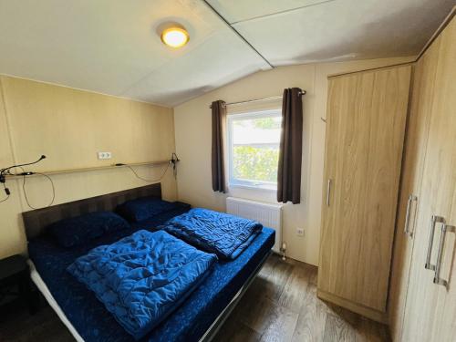 een kleine slaapkamer met een blauw bed erin bij Vakantiepark Kijkduin - 711 in Den Haag