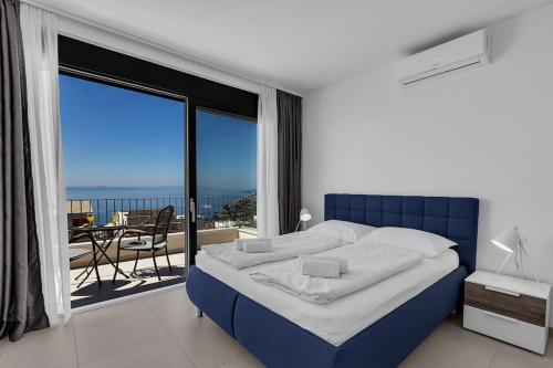 a bedroom with a blue bed and a large window at Ferienhaus Komplex - Villa Oliver - Makarska Exklusiv in Veliko Brdo