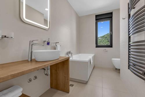 a white bathroom with a sink and a toilet at Ferienhaus Komplex - Villa Oliver - Makarska Exklusiv in Veliko Brdo