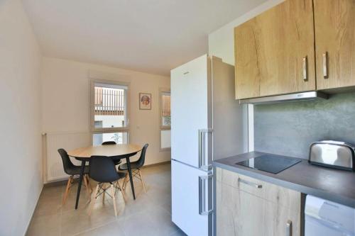 a kitchen with a table and a white refrigerator at Appartement Samoens l'Etelley in Samoëns