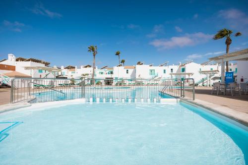 a swimming pool with blue water in a resort at Smy Tahona Fuerteventura in Caleta De Fuste
